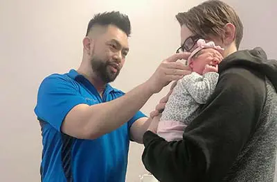 Chiropractor Carpentersville IL Dr. Phillip Que With Pediatric Patient